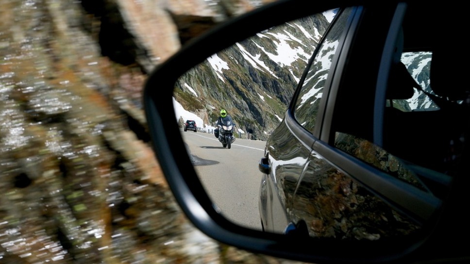Мотоциклист в зеркале со световозвращающим шлемом